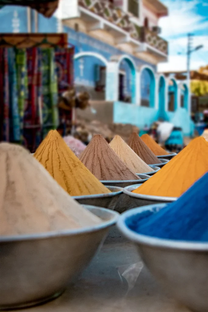 Mounds of colourful goods in metal bowls at a market in Aswan